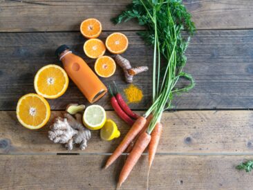 sliced orange fruit and green leaves on brown wooden table